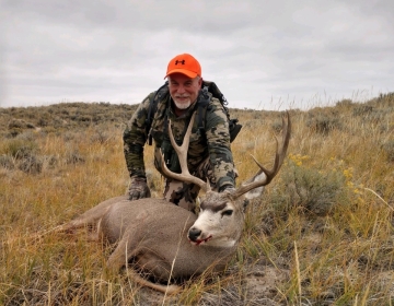 Hunter with his mule deer after the hunt
